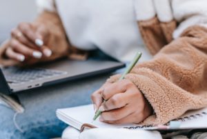 laptop writing in notebook