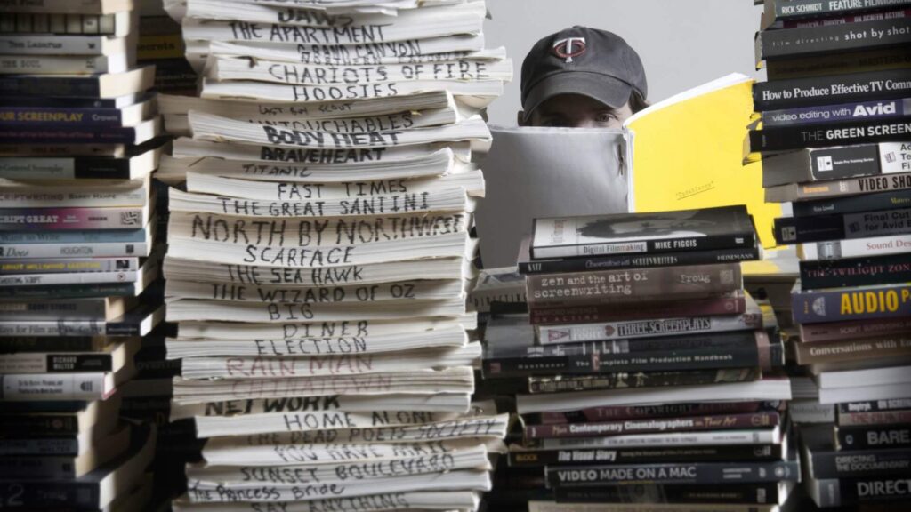 A man reading a stack of scripts, 7 Jobs That Can Put Screenwriters in the Industry Spotlight