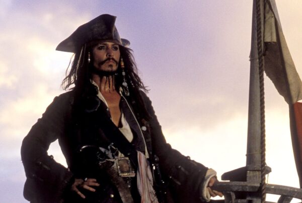 Jack Sparrow (Johnny Depp) standing on top of his ship as it sinks into the sea in 'Pirates of the Caribbean: The Curse of the Black Pearl' (2003)