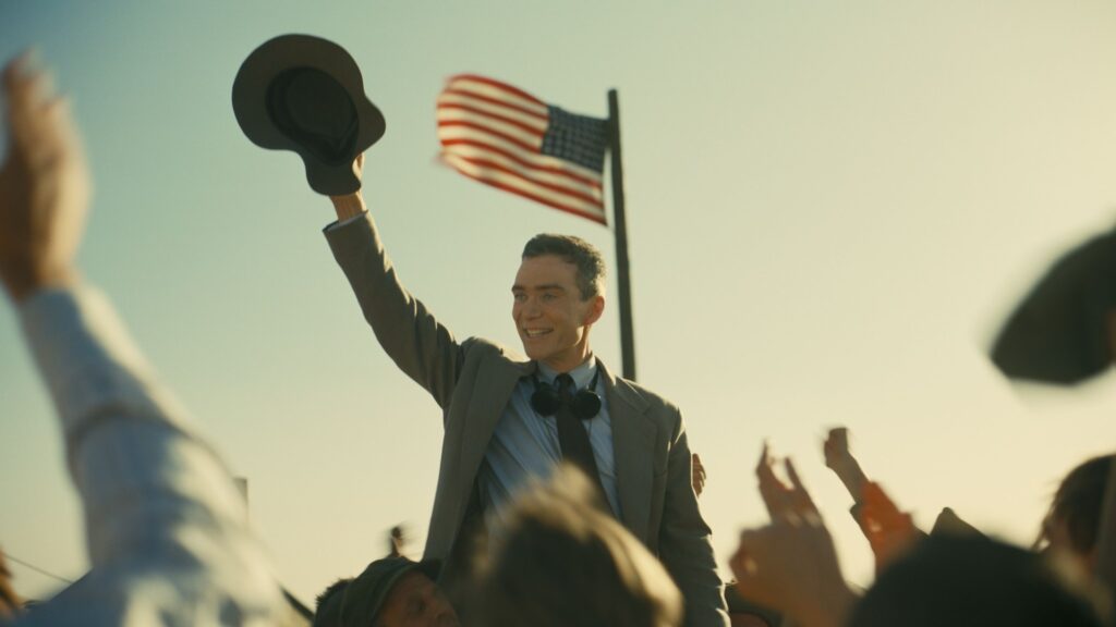 J. Robert Oppenheimer (Cillian Murphy) celebrating with a crowd in 'Oppenheimer'